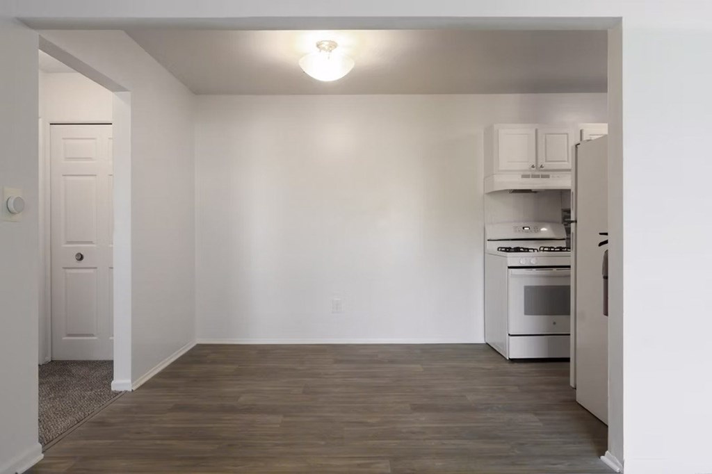 A kitchen with white cabinets and a white oven.