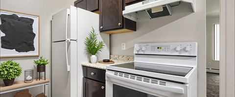 A white refrigerator stands next to a white oven in a kitchen.