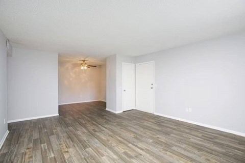 A room with a ceiling fan and a door.
