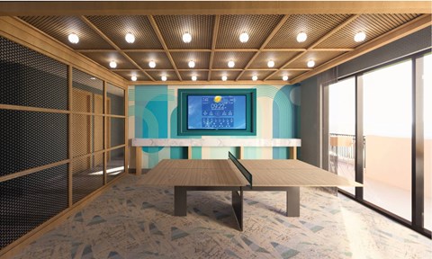 A room with a wooden table and a television screen showing the time as 02:22.