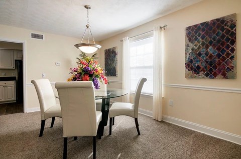 A dining room with a glass table and chairs.