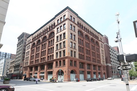 A large red brick building with a green roof and a street sign that says "one way".