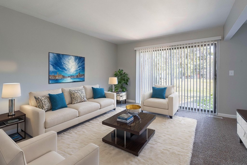 A living room with a white couch, a coffee table, and a painting on the wall.