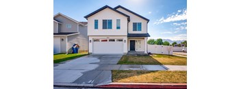 A two-story house with a garage and a driveway.