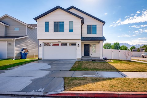 A two-story house with a garage and a driveway.