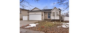 A house with a grey garage door and a black front door.