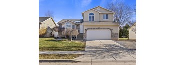 A house with a garage and a driveway in front.
