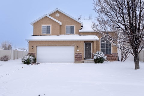 A house with a white garage door and a brown roof.