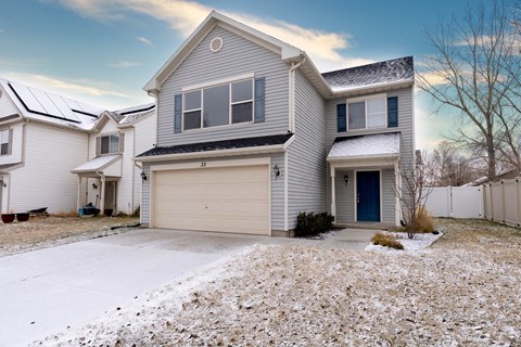 A house with a garage and a driveway covered in snow.