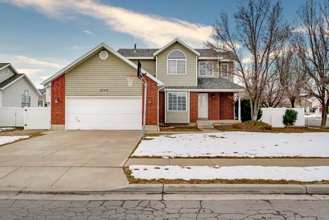 A house with a garage and a driveway in front.
