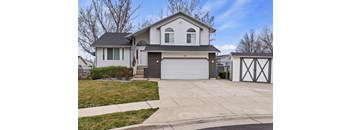 A house with a grey roof and a white garage door.