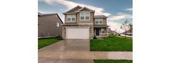 A two-story house with a garage and a driveway.