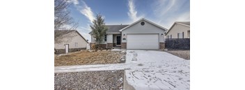 A house with a garage and a driveway covered in snow.