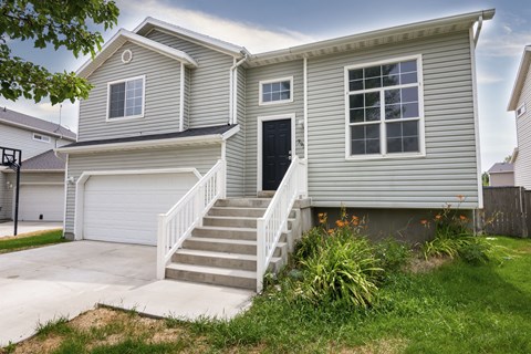 A house with a grey siding and a black door.