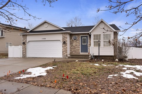 A house with a grey garage door and a black front door.