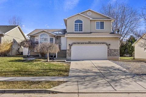 A house with a garage and a driveway in front.