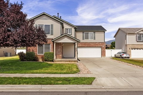 A house with a grey roof and a white garage door.