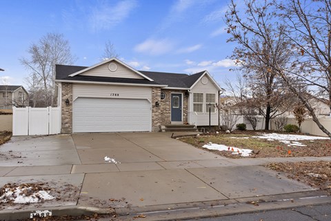 A house with a garage and a driveway in front.