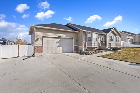 A house with a garage and a driveway in front.