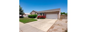 A house with a garage and a driveway in front.