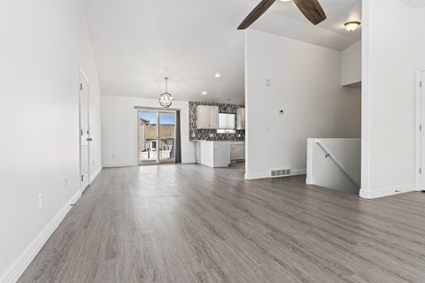 A spacious room with a ceiling fan and lighting fixture.