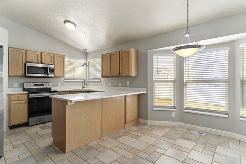 A kitchen with wooden cabinets and a tiled floor.