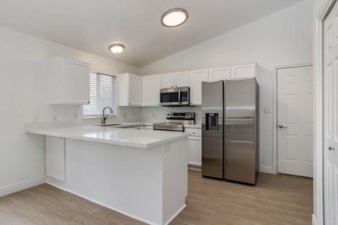 A kitchen with white cabinets and a white island.