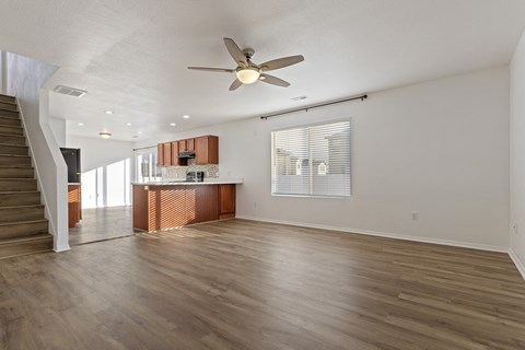 A spacious room with a ceiling fan and wooden flooring.
