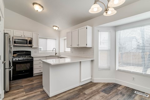 A kitchen with white cabinets and a black stove top oven.