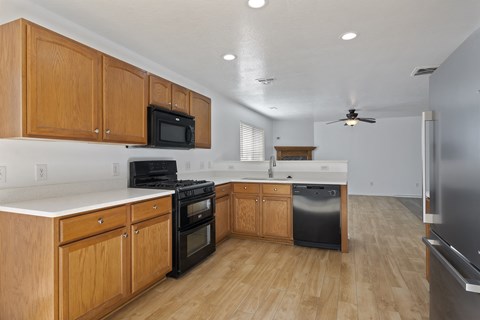 A kitchen with wooden cabinets and black appliances.