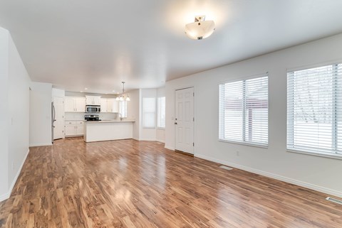 A spacious room with wooden floors and white walls.