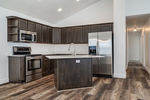 A kitchen with dark wood cabinets and stainless steel appliances.