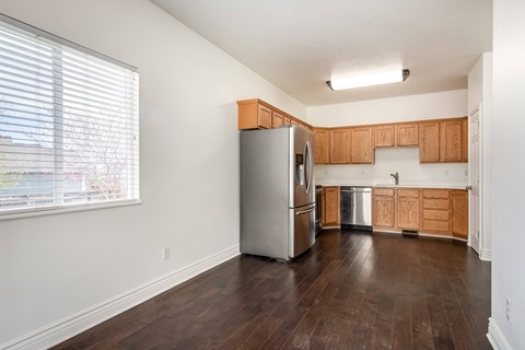A kitchen with wooden cabinets and a stainless steel refrigerator.