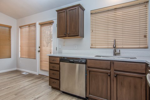 A kitchen with wooden cabinets and a dishwasher.