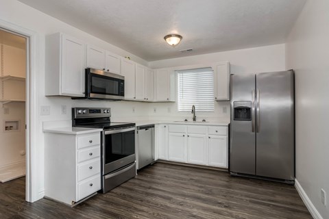 A kitchen with white cabinets and stainless steel appliances.
