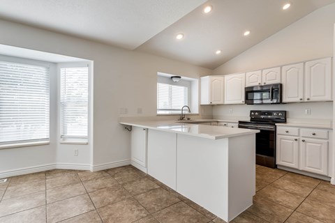 A kitchen with white cabinets and a large island.