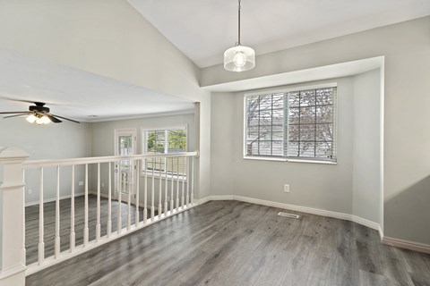 an empty living room with a staircase and a window
