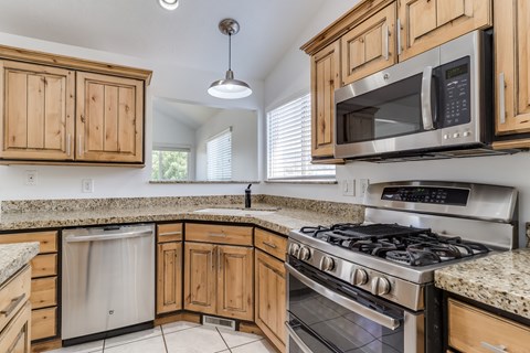 A kitchen with wooden cabinets and granite countertops.