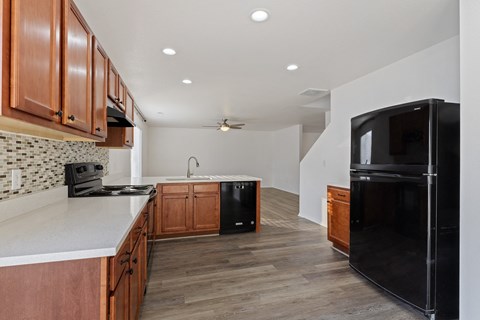 A kitchen with wooden cabinets and black appliances.