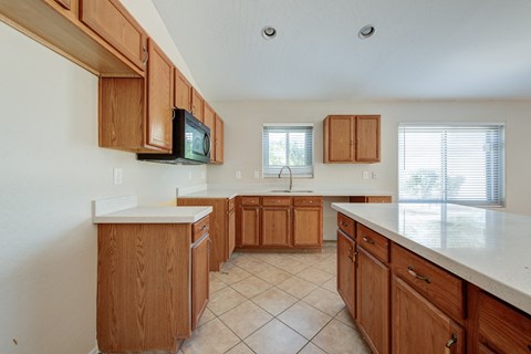 A kitchen with wooden cabinets and a white countertop.