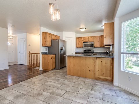 A kitchen with wooden cabinets and a tiled floor.