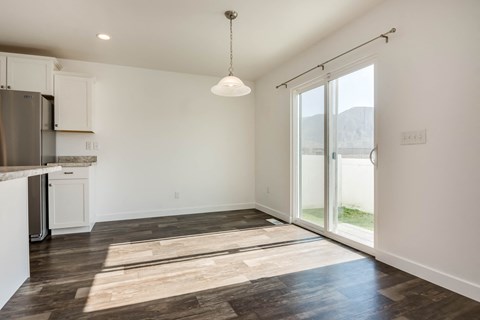 A kitchen with white cabinets and a wooden floor.