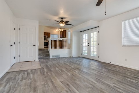 A spacious room with a wooden floor and a ceiling fan.