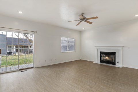 A spacious living room with a fireplace and sliding glass doors.