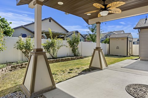 A patio with a ceiling fan and a concrete floor.