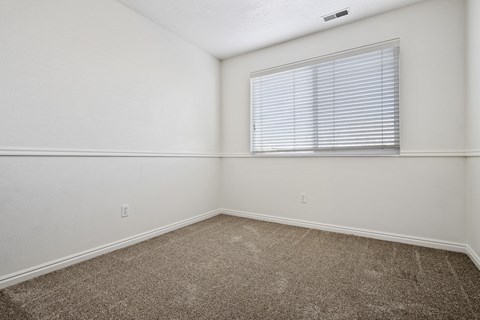 an empty room with carpet and a window