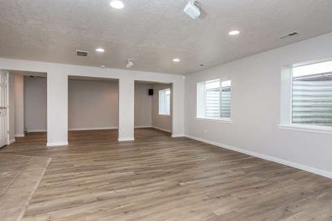 an empty living room with a wooden floor and white walls