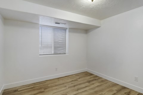 an empty room with white walls and a window