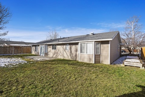 the back of a house with a yard and a fence