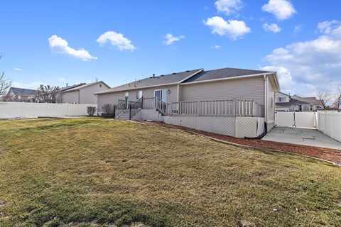 A house with a grey roof and a fence in front of it.